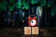 December 31st set on wooden calendar with red alarm clock on dark blured background.