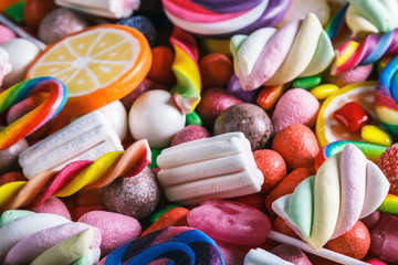 Wall Mural - different colors of candy, lollipops, chewing gum, marshmallow and other sweets. The background is sweet