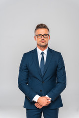 handsome businessman in suit and glasses looking at camera isolated on white