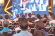 © THANANIT - Rear view of Audience listening Speakers on the stage in the conference hall or seminar meeting, business and education about investment concept