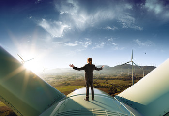Wall Mural - happy businessman feel success after good work. he standing a top of windmill and looking beautiful 