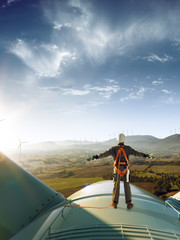 Wall Mural - happy engineer feel success after good work. he standing a top of windmill and looking beautiful sun