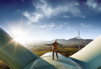 Wall Mural - happy engineer feel success after good work. he standing a top of windmill and looking beautiful sun