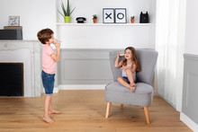 Boy And Girl Playing With Tin Can Telephone