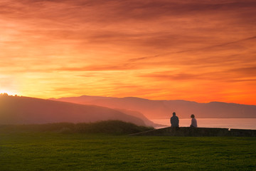 Poster - Couple watching beautiful sunset on the coast