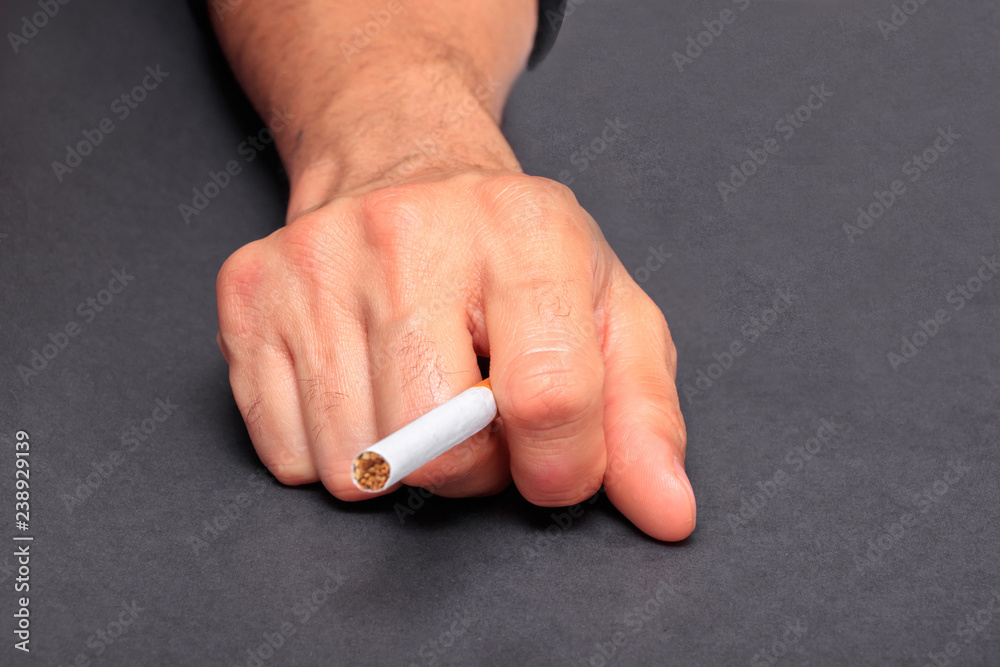Man holding cigarette between fingers Stock Photo