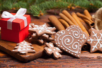 Sticker - Red gift box and decorated gingerbread Christmas cookies on wooden table