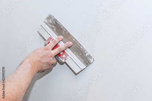 Fotografía Hand with trowel, repair wall, Trowel with putty structure, the process of applying a layer of trowel, work with putty