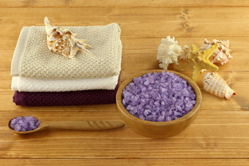 Lavender sea salt for bath in bamboo bowl on light brown wooden table