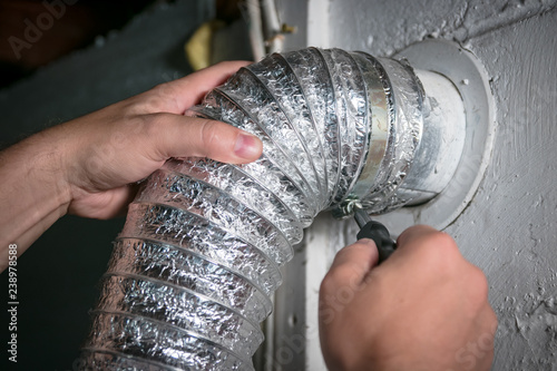Fotografía Flexible dryer vent hose, attaching/detaching from wall vent by turning screw in steel duct clamp