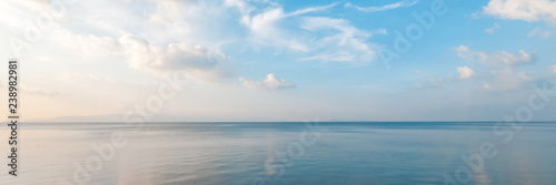 Zdjęcie XXL Jasny piękny krajobraz morski, piaszczysta plaża, chmury odbijające się w wodzie, naturalne minimalistyczne tło i tekstura, transparent z panoramicznym widokiem