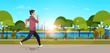 © mast3r - young man jogging outdoors modern public park guy in headphones running sport activity concept cityscape sunset background horizontal banner flat