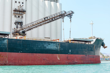 Wall Mural - cargo ship loads containers in the industrial port of Barcelona