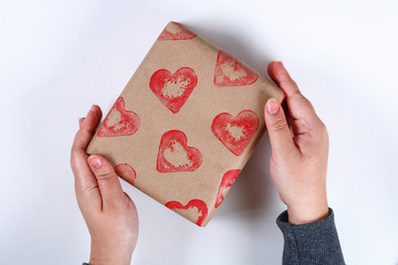 Diy. Gift wrapping for Valentine's Day. Kraft paper gift and potato stamp in the shape of a heart and red paint do it yourself on February 14th. Top view on a white background. step by step.