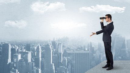 Wall Mural - businessman looking forward to a city with binoculars from skyscraper concept