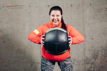 crazy angry woman with a ball. close up photo. funny fat sportswoman having fun with ball.