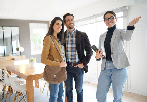 Cuadros en Lienzo Real estate agent showing modern house to attractive couple