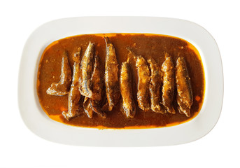 anchovy fish in tomato sauce on a white plate isolated on white background