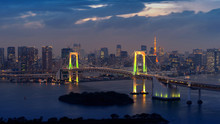 View Of Tokyo Cityscape And Rainbow Bridge At Night In Japan.