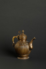 Wall Mural - ancient oriental metal teapot on dark background. antique bronze tableware