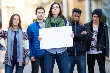 Diverse group of people protesting with blank sign