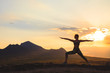 © davit85 - Silhouette of young woman practicing yoga or pilates at sunset or sunrise in beautiful mountain location.