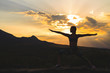 © davit85 - Silhouette of young woman practicing yoga or pilates at sunset or sunrise in beautiful mountain location.