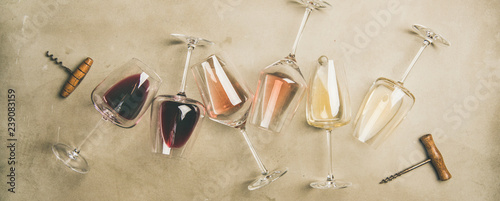 Fotomural Flat-lay of red, rose and white wine in glasses and corkscrews over grey concrete background, top view, wide composition