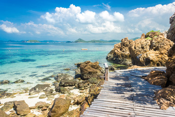 Sticker - Tropical island rock and wood bridge on the beach with blue sky. Koh kham pattaya thailand.