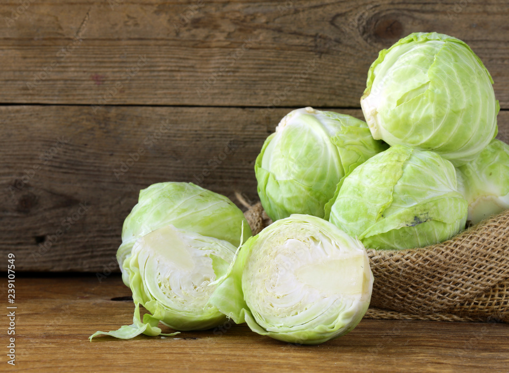 Ripe white cabbage on a wooden table - obrazy, fototapety, plakaty 