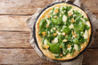 Italian cuisine thin pizza with fresh spinach, garlic and cheese close-up on a board. horizontal top view