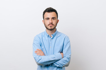 Wall Mural - Photo of seriously man in blue shirt with crossed hands