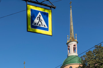 Pedestrian walk sign on a blue sky and architectural detail in Saint Petersburg