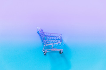 Empty the cart of a supermarket on the gradient and holographic background