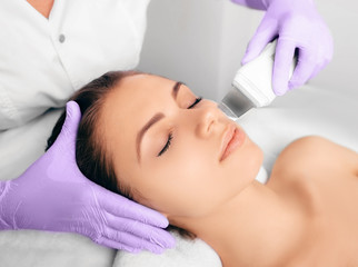 Wall Mural - Beautiful woman receiving ultrasound cavitation facial peeling. Cosmetology and facial skin care