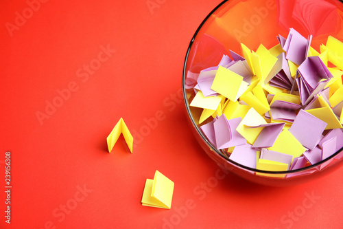 Fotografía Paper pieces for lottery in glass vase on color background