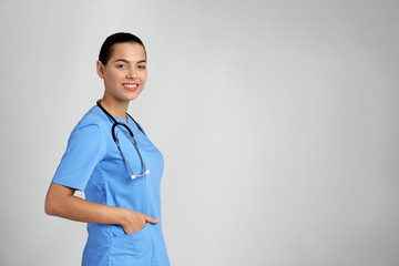 Wall Mural - Portrait of young medical assistant with stethoscope on color background. Space for text