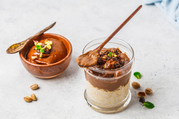 Canvas Print - Overnight oatmeal with milk and chocolate mousse in glass on a white background.