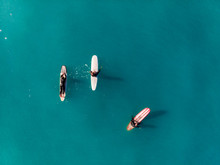 Three Surfers In Open Sea Warm Sunny Day. Close Up. Top View Aerial Drone