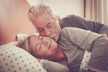 Home Lovely Scene With Couple Of Senior Kissing In The Bedroom At The Morning Ready To Wake Up And Start The Day Together  Forever - Married Lifestyle And Happiness For Elderly People At Home