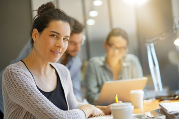 Wall Mural - Focus on attractive brunette looking at camera in co working space