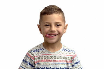 portrait of a cheerful boy on a white background that shows tongue