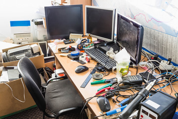 A messy desktop with stacks of files and other documents, all kind of office supplies and part of a keyboard.