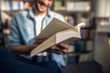 © Dusan Petkovic - Student reading a book while sitting in library. Selective focus on book.