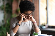 © fizkes - Upset African American woman talking on phone, frustrated sad female touching face, get unpleasant call, worried about problem with work or relationships, hearing, receiving bad news concept