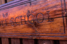 Wooden Sign With The School Inscription Engraved On It.