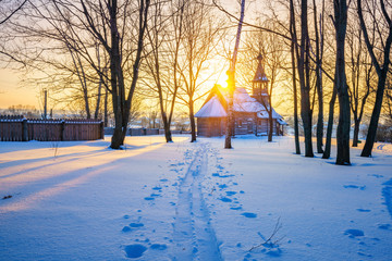 Wall Mural - Small russian church in winter park at sunset