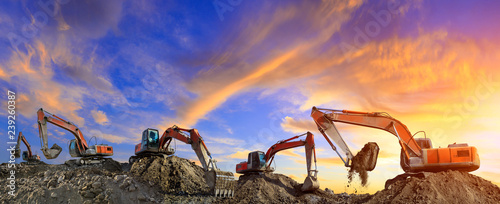 Cuadros en Lienzo Many excavators work on construction site at sunset,panoramic view