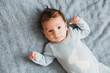 © Ольга Тернавская - Newborn pretty baby boy in blue sleepwear lying on grey sheet, top view