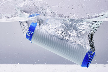 New carbon filter cartridge for house water filtration system isolated on white background. Splash. Concept.